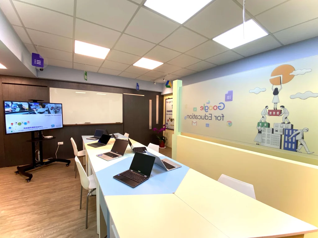 鴻綸科技教育訓練中心教室，牆面有 Google for Education 主視覺，桌上排放 Chromebook 與大型顯示器